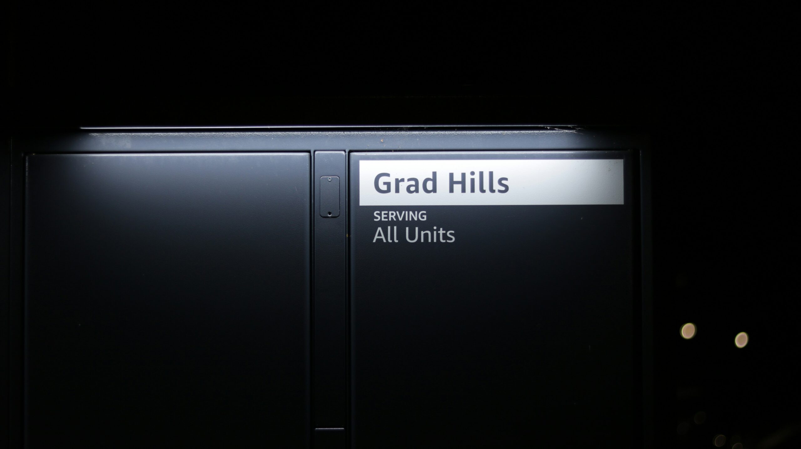 A black door with a sign that reads grad hills serving all units