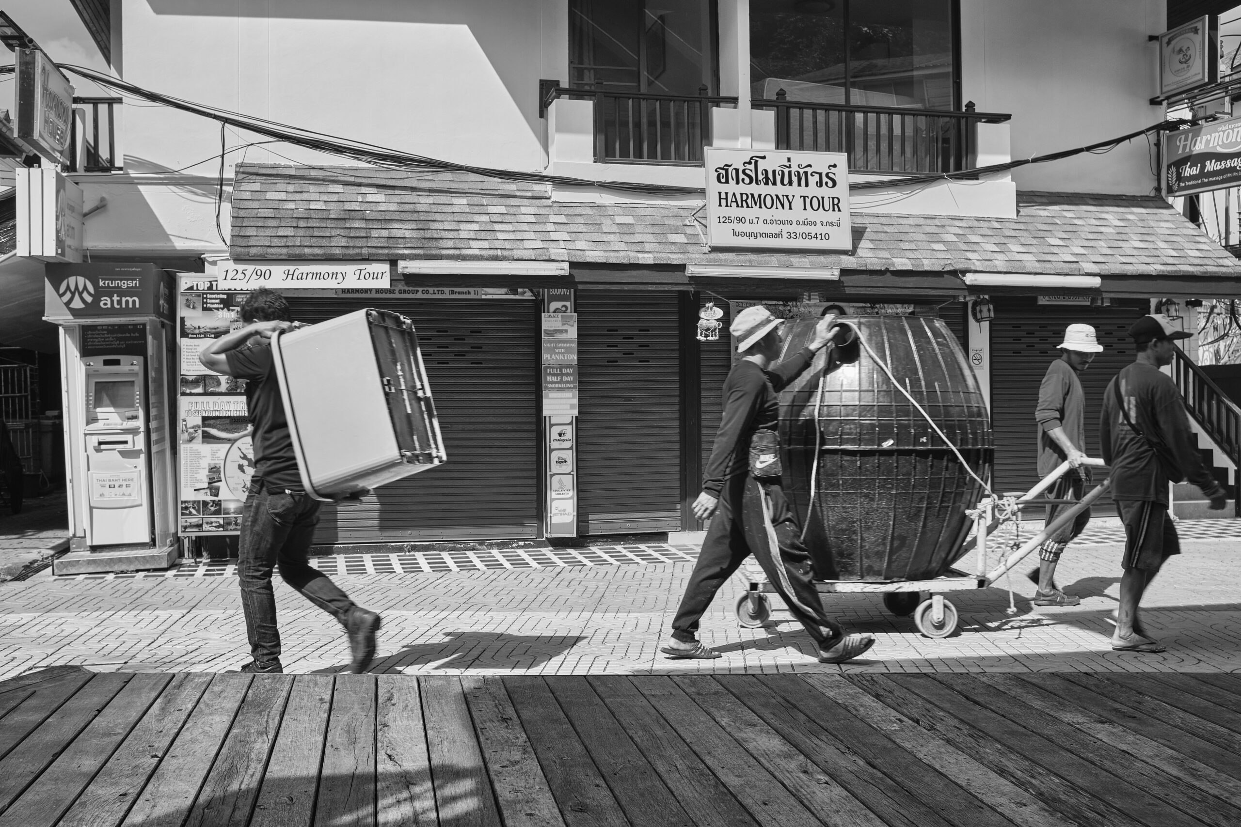 Grayscale photo of man and woman walking on wooden pathway