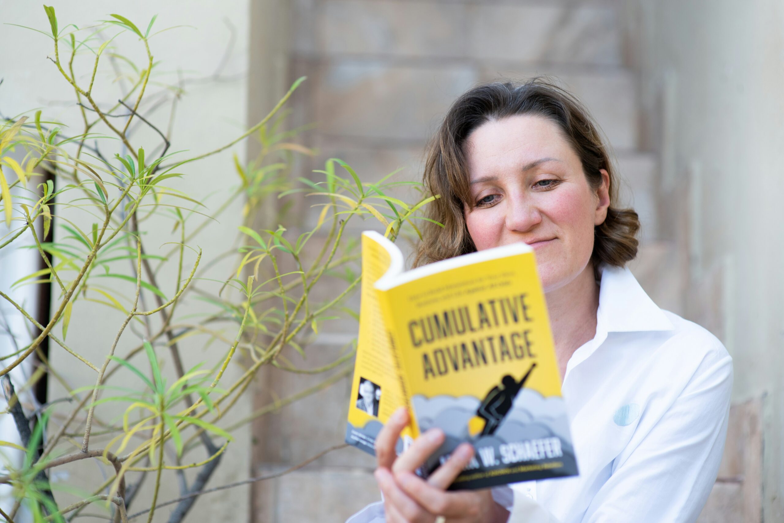 Woman in white dress shirt holding yellow book