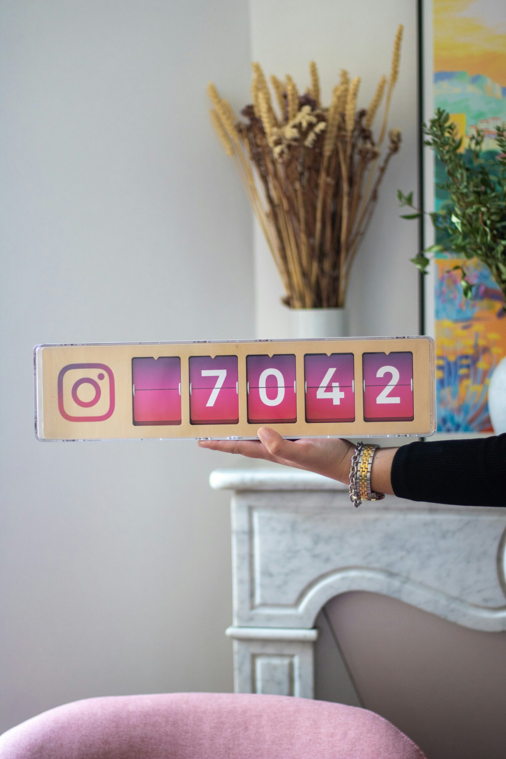 A woman holding up a wooden block with numbers on it